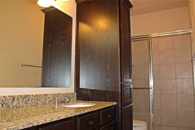 bathroom with vanity, toilet, tile walls, and a shower with door