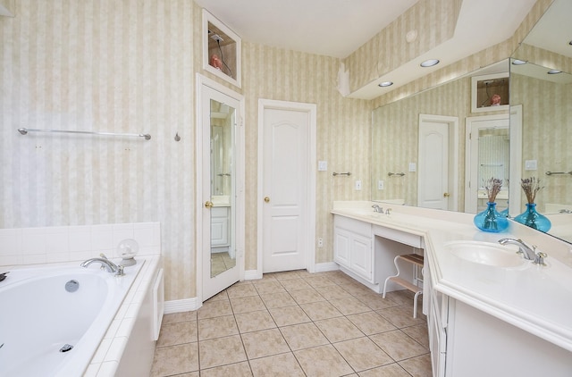 bathroom featuring a relaxing tiled tub, tile patterned floors, and vanity