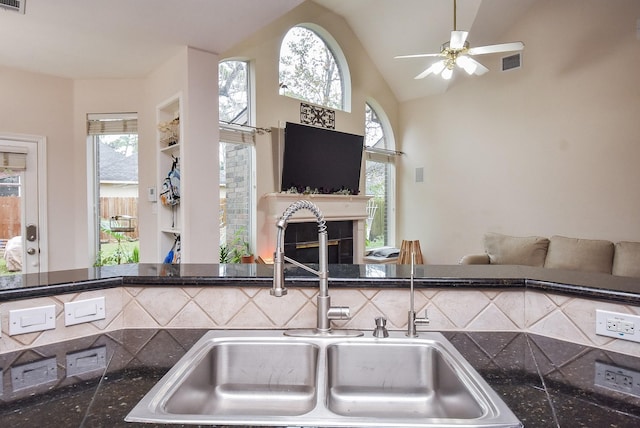 kitchen with ceiling fan, vaulted ceiling, a healthy amount of sunlight, and sink