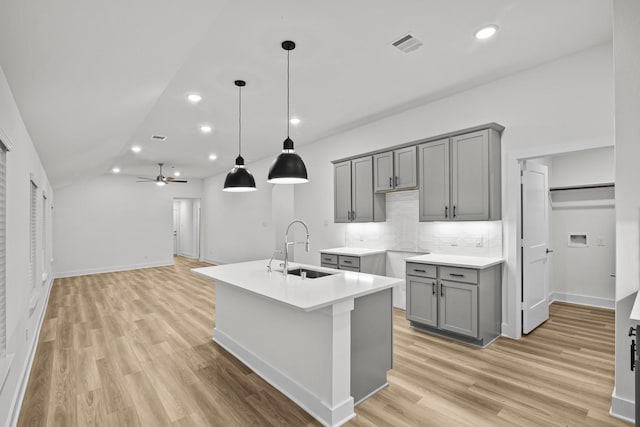 5822 Dawning Sun St, Fulshear, TX 77441 - kitchen featuring gray cabinets, a sink, tasteful backsplash, light wood finished floors, and recessed lighting