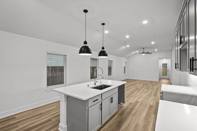 5822 Dawning Sun St, Fulshear, TX 77441 - kitchen featuring a sink, baseboards, light countertops, light wood-style flooring, and lofted ceiling