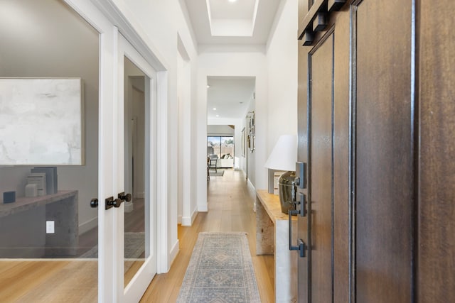 corridor featuring french doors and light hardwood / wood-style flooring