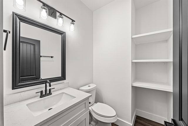 bathroom with toilet, wood-type flooring, and vanity