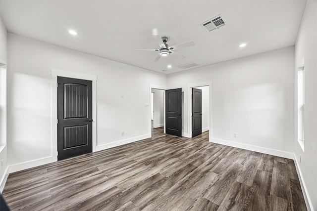 unfurnished bedroom with ceiling fan and dark hardwood / wood-style flooring