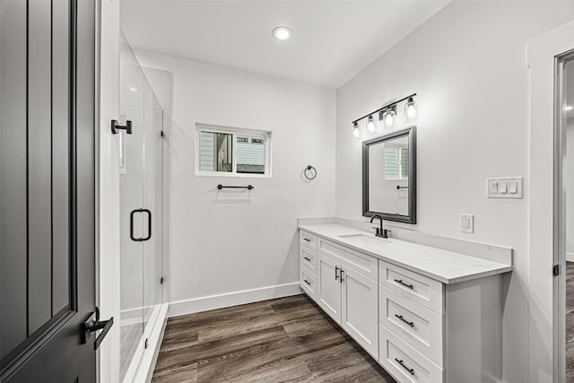 bathroom featuring walk in shower, vanity, and hardwood / wood-style flooring