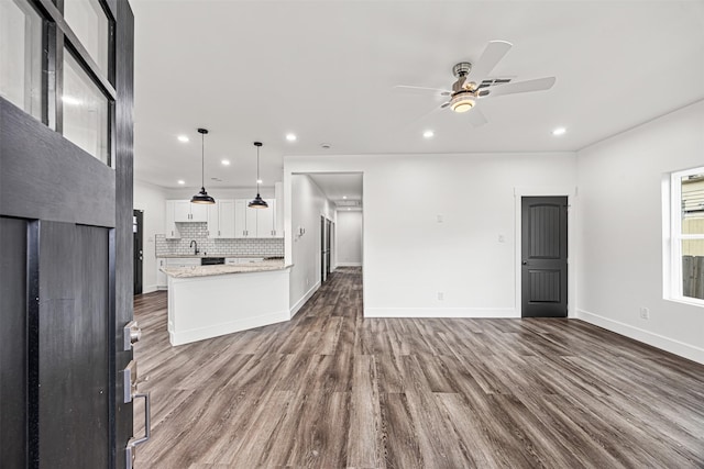 unfurnished living room with ceiling fan and hardwood / wood-style floors