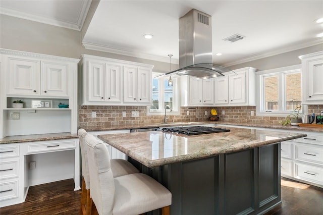 kitchen with white cabinets, island exhaust hood, hanging light fixtures, light stone countertops, and a kitchen island