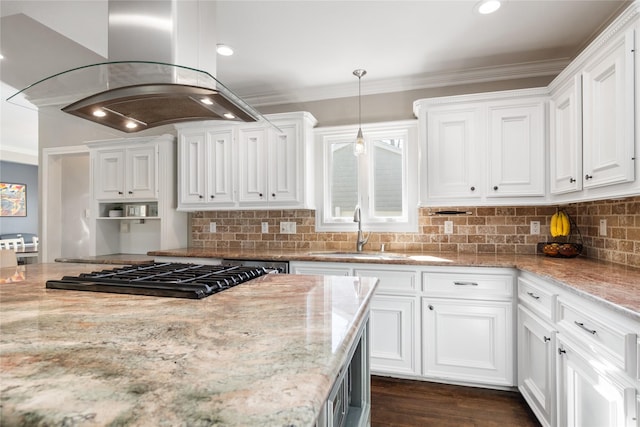 kitchen with sink, white cabinetry, hanging light fixtures, light stone countertops, and island range hood