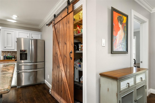 kitchen with white cabinetry, ornamental molding, a barn door, stainless steel fridge with ice dispenser, and dark wood-type flooring