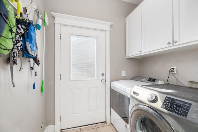 laundry room with cabinets, light tile patterned flooring, and independent washer and dryer