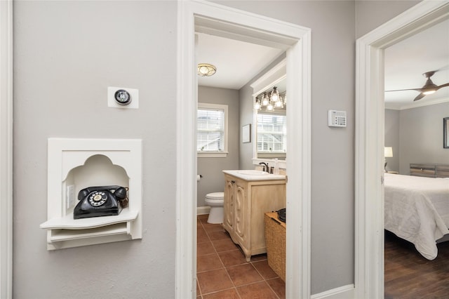 bathroom featuring toilet, tile patterned flooring, crown molding, ceiling fan, and vanity