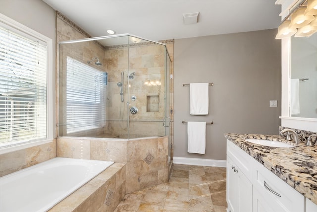 bathroom featuring shower with separate bathtub, a wealth of natural light, and vanity