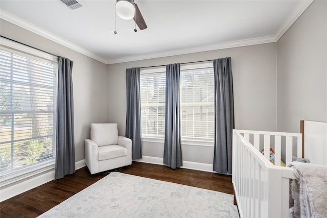 bedroom featuring a nursery area, ceiling fan, ornamental molding, and dark hardwood / wood-style floors