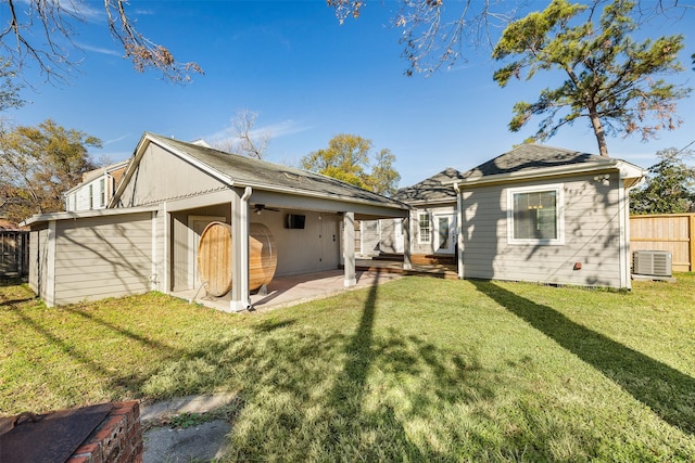 back of property with a lawn, a patio area, and central AC unit