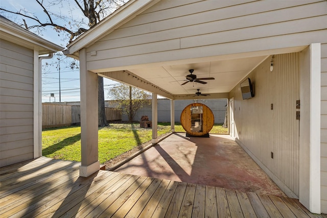 wooden deck featuring ceiling fan and a lawn