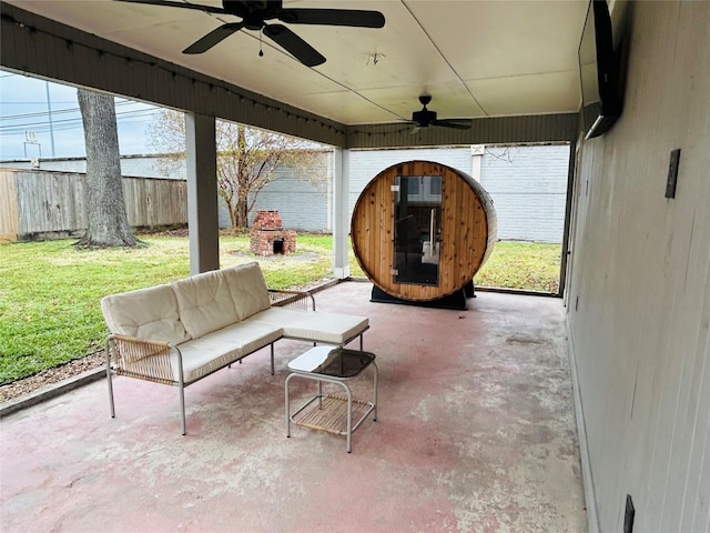 view of patio with ceiling fan and an outdoor living space with a fireplace