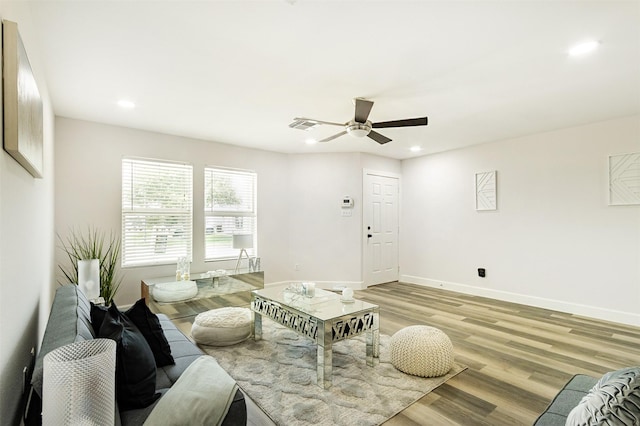 living room with ceiling fan and light hardwood / wood-style flooring