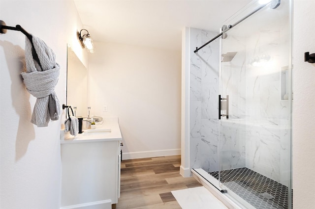 bathroom featuring hardwood / wood-style flooring, a shower with shower door, and vanity