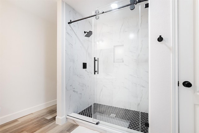 bathroom featuring a shower with door and wood-type flooring