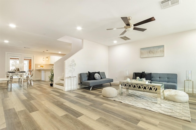 living room featuring ceiling fan and light hardwood / wood-style flooring