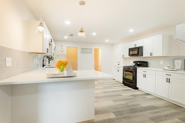 kitchen featuring backsplash, white cabinets, black appliances, and hanging light fixtures