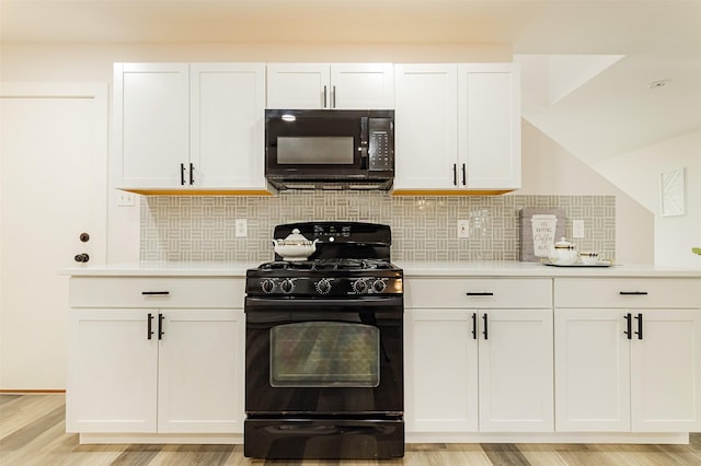 kitchen featuring backsplash, white cabinets, and black appliances