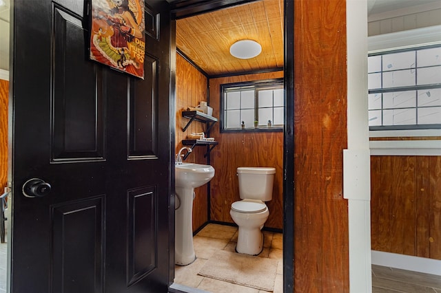 bathroom with sink, wood ceiling, wooden walls, and toilet