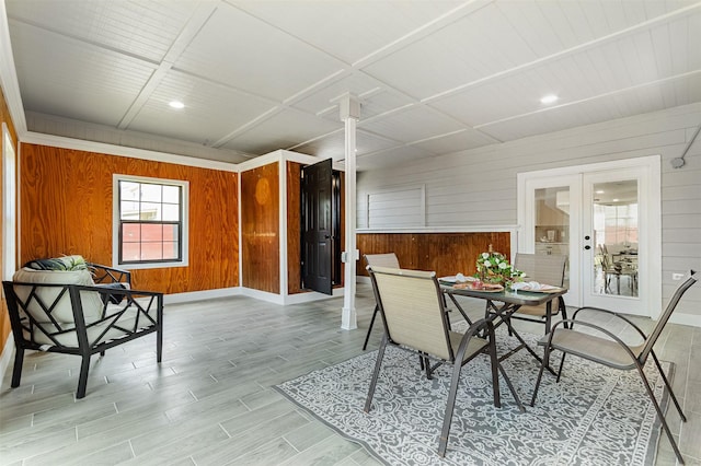 dining area featuring french doors and wood walls