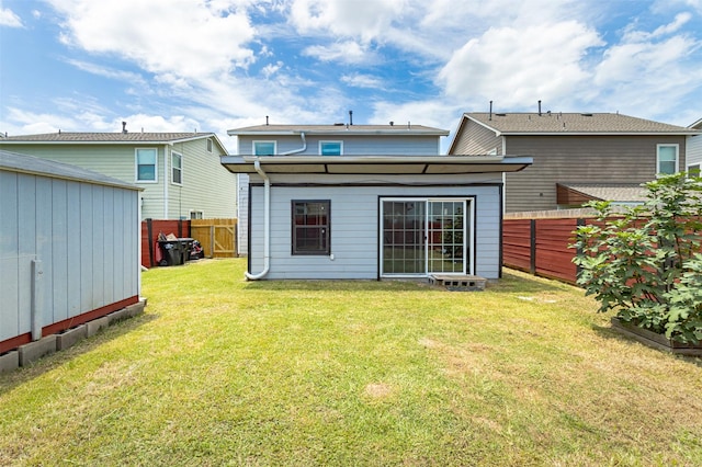 rear view of property featuring a lawn