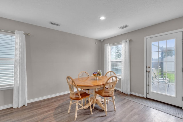 dining space featuring a textured ceiling and hardwood / wood-style floors