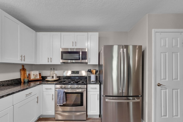 kitchen with white cabinets, a textured ceiling, and appliances with stainless steel finishes