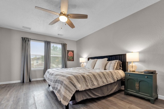 bedroom featuring ceiling fan, a textured ceiling, and wood-type flooring