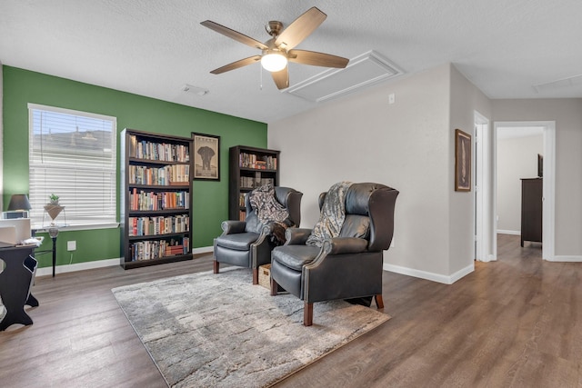 living area featuring ceiling fan, a textured ceiling, and hardwood / wood-style flooring