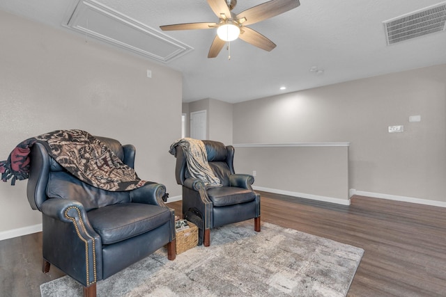 sitting room with ceiling fan and dark hardwood / wood-style flooring