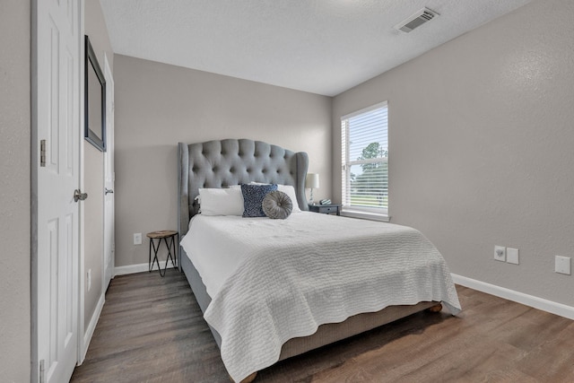 bedroom with dark wood-type flooring and a textured ceiling