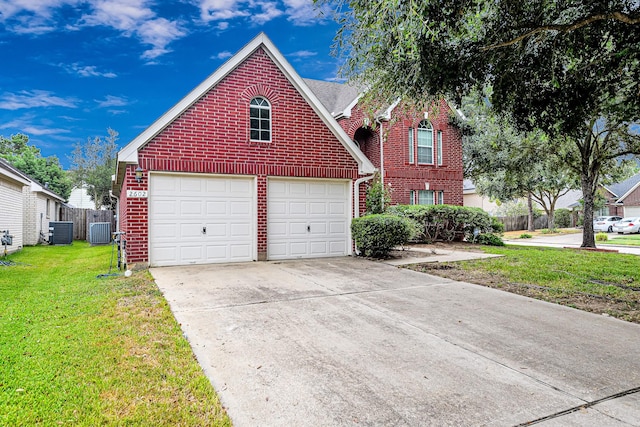 view of front of property featuring a front lawn, cooling unit, and a garage