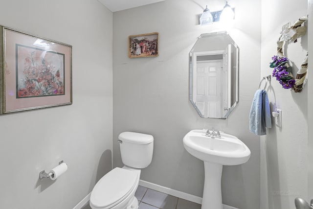 bathroom featuring toilet, tile patterned floors, and sink