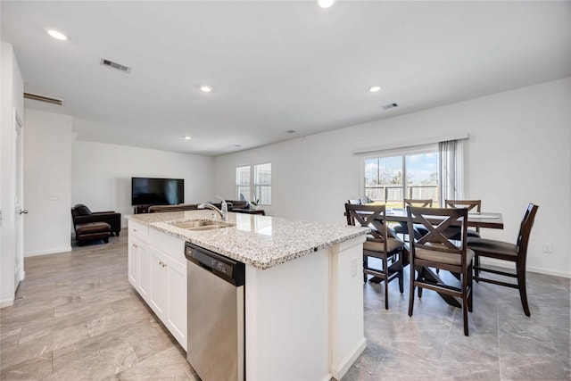 kitchen with light stone countertops, dishwasher, a center island with sink, white cabinetry, and sink