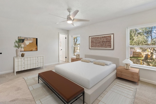 carpeted bedroom featuring ceiling fan and multiple windows