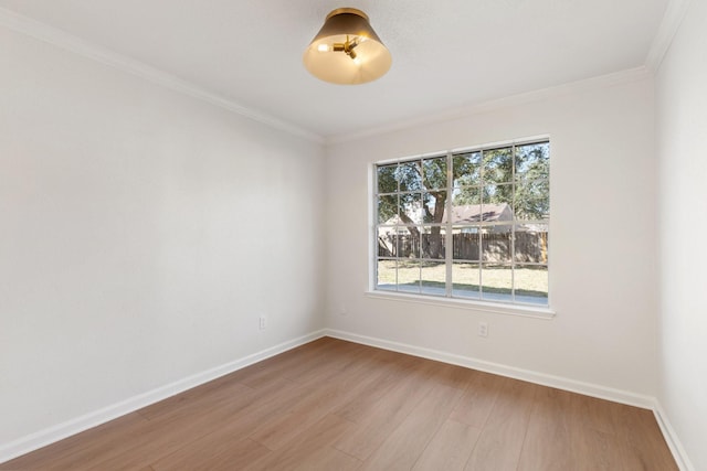 empty room featuring light wood-type flooring, a wealth of natural light, and ornamental molding