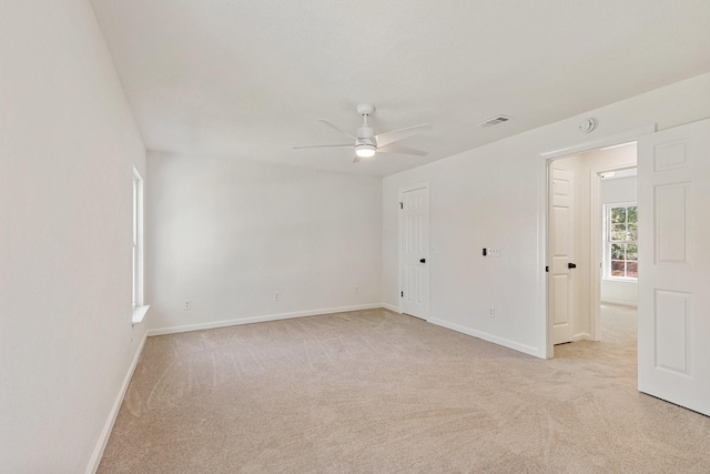 unfurnished room with ceiling fan and light colored carpet