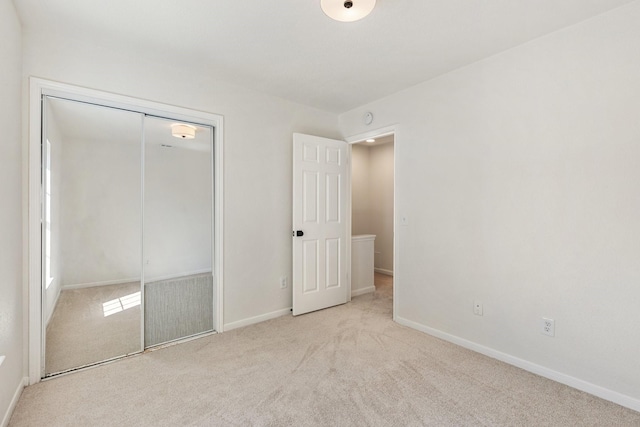 unfurnished bedroom with a closet and light carpet