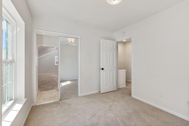 unfurnished bedroom with light colored carpet and a closet