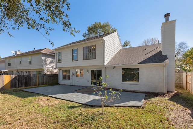 rear view of house featuring a deck and a lawn