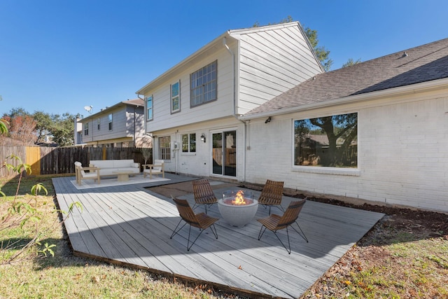 back of house featuring an outdoor living space with a fire pit and a deck