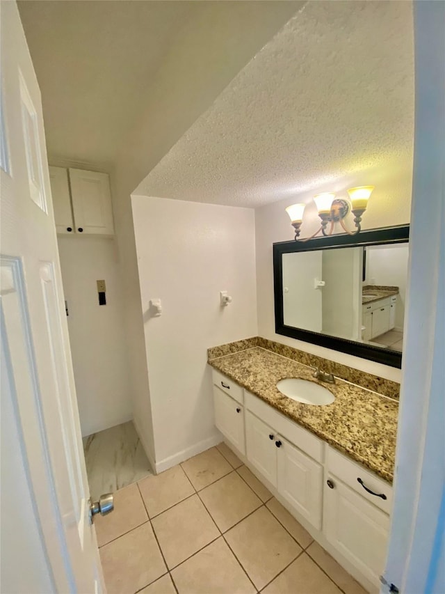 bathroom with a textured ceiling, tile patterned floors, and vanity