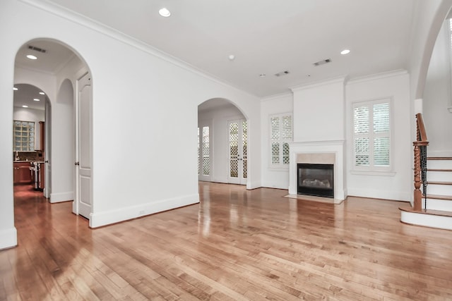 unfurnished living room with ornamental molding and light hardwood / wood-style flooring