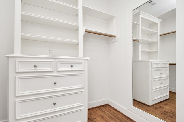 walk in closet with dark hardwood / wood-style flooring