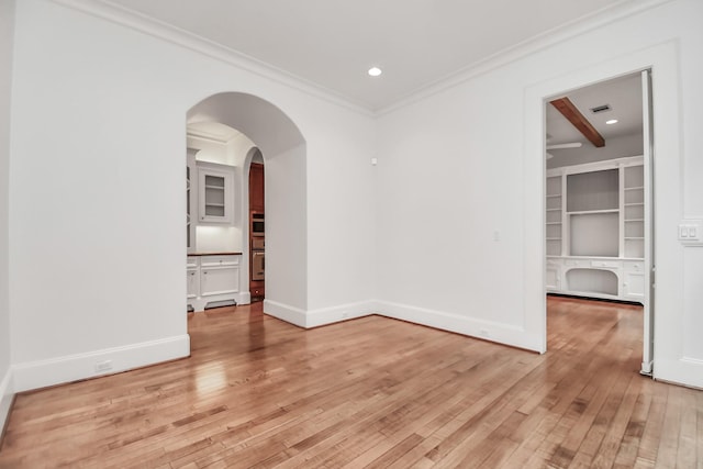 empty room with ornamental molding and light hardwood / wood-style floors