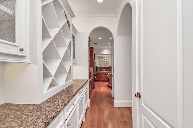 hallway with hardwood / wood-style floors and crown molding